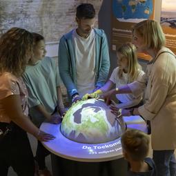 Kinderen leggen hand op lichtgevende wereldbol