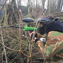 Gecamoufleerde paintballer tussen takken