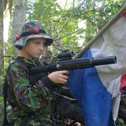 Gecamoufleerde lasergamer met Nederlandse vlag tussen takken