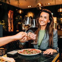 Vrouw proost met wijnglazen